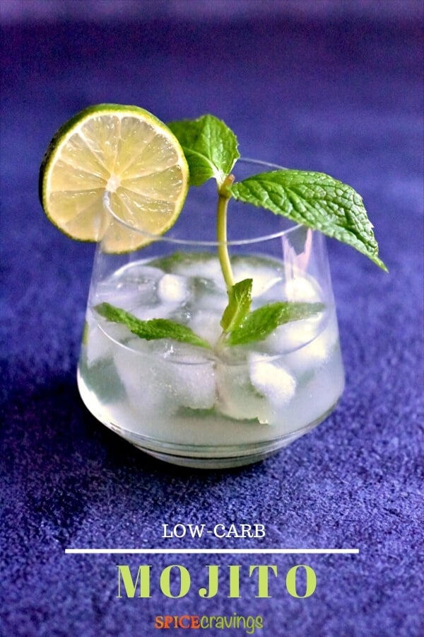 low carb mojito in cocktail glass garnished with lime slice and mint leaves with blue background