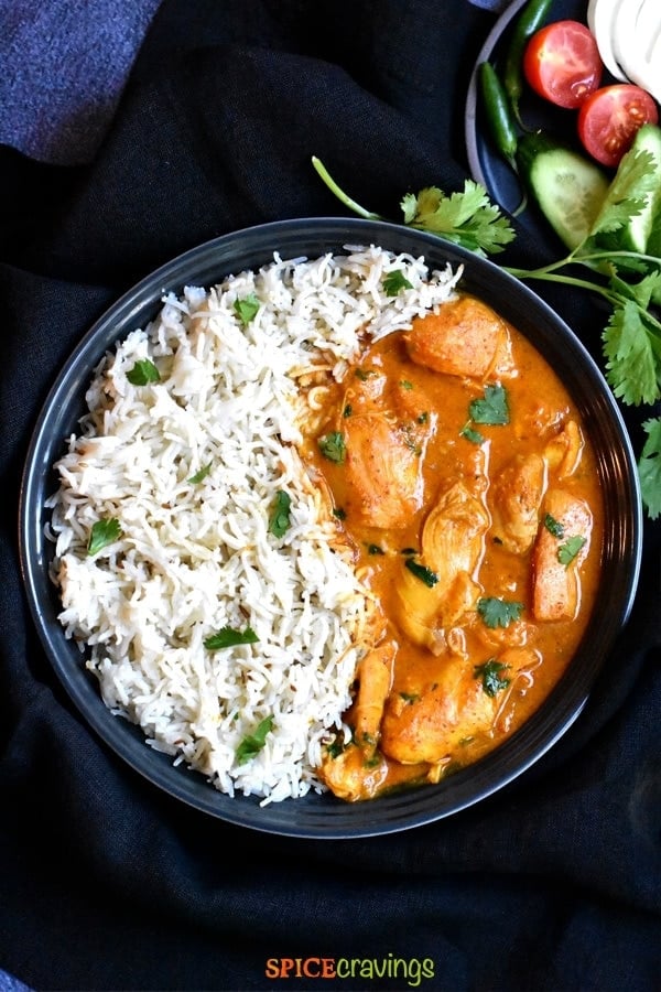 instant pot chicken korma with cumin rice in black bowl with fresh cilantro