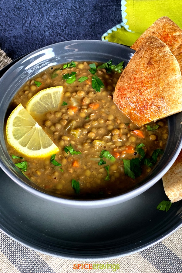 instant pot lentil soup in gray bowl with lemon slices and pita