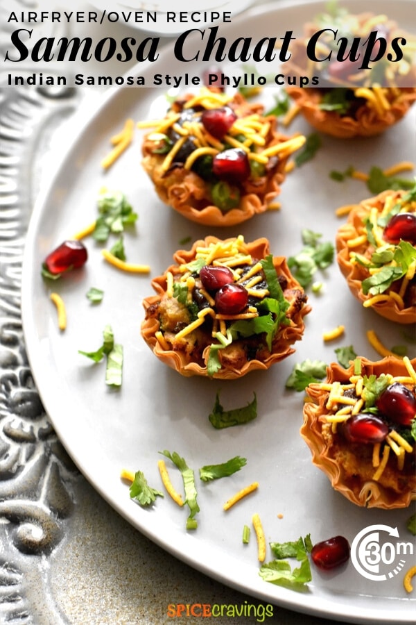 samosa chaat phyllo cups garnished with cilantro, pomegranate seeds and thin sev on white plate