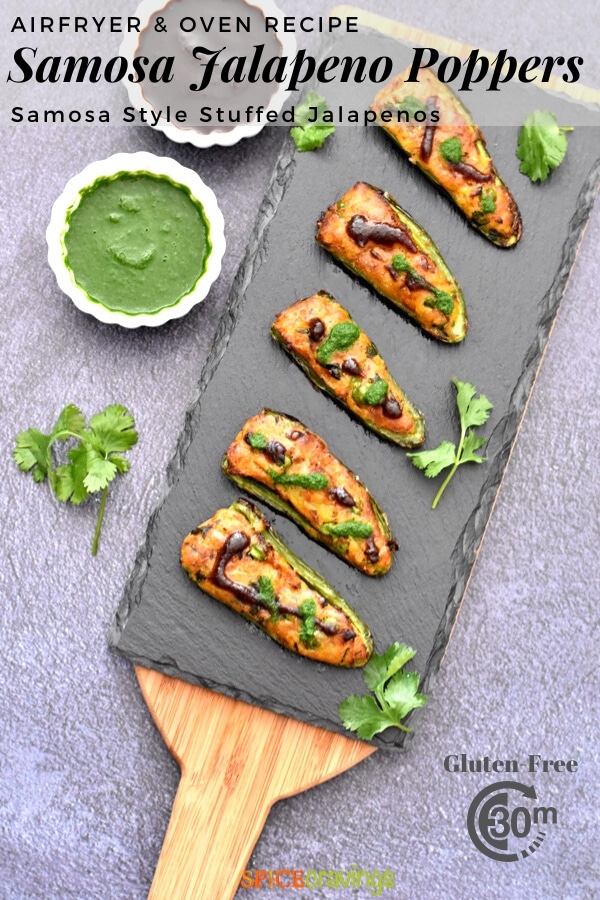 stuffed jalapeno peppers on charcoal board with cilantro chutney in small white bowl