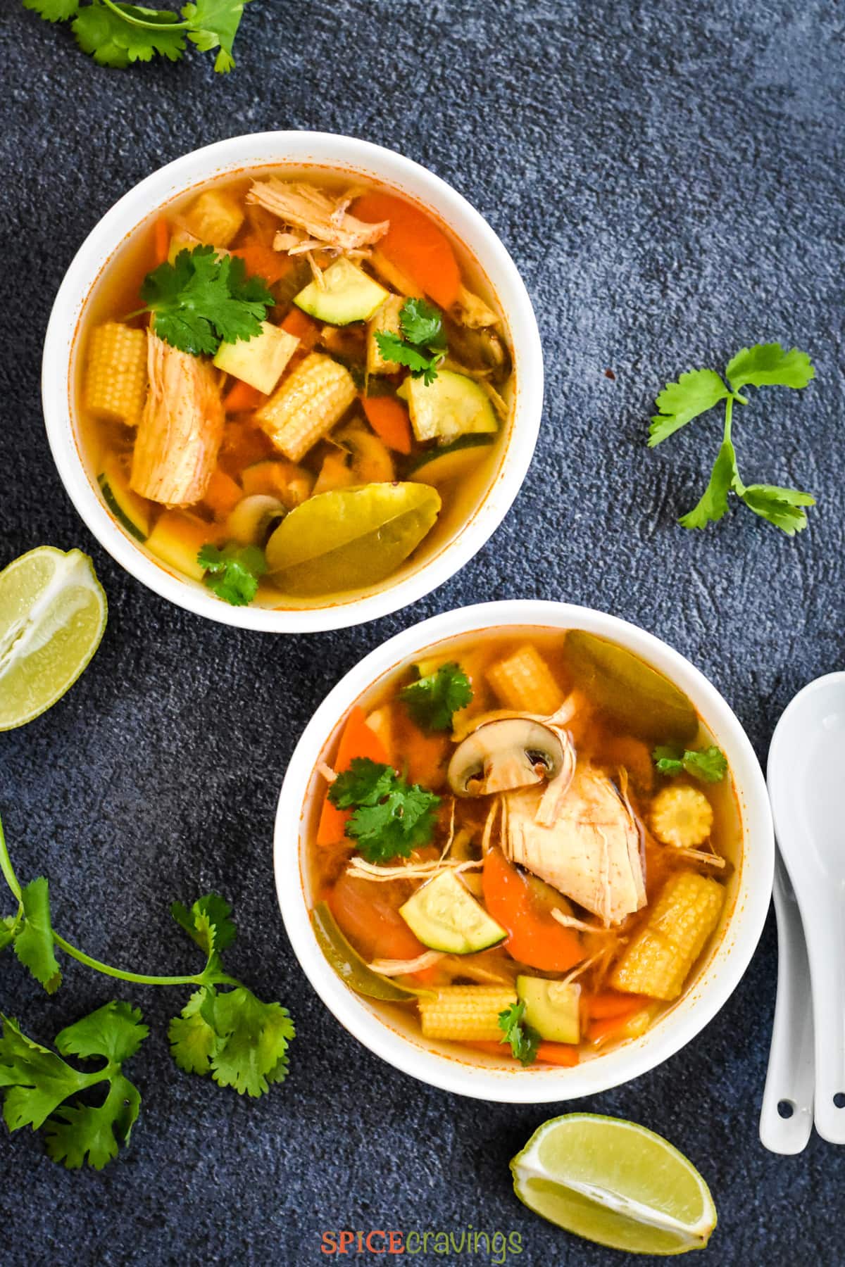 Two bowls of Thai Tom Yum Soup with mushroom, chicken and carrots.