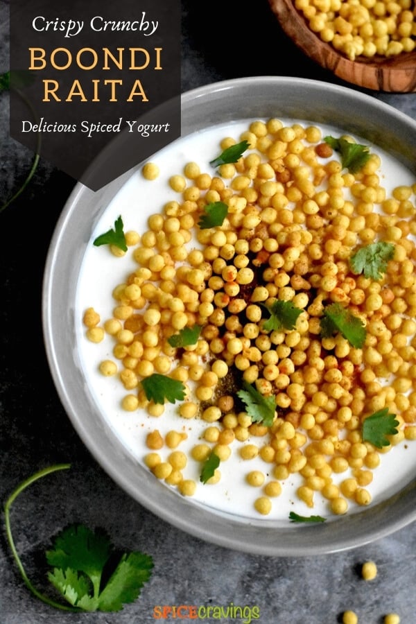 spiced yogurt sauce with fried chickpea balls in gray bowl with boondi on side