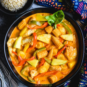 chicken, mango and baby corn curry in black bowl