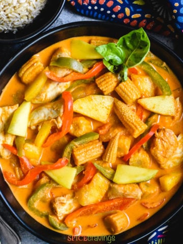 chicken, mango and baby corn curry in black bowl
