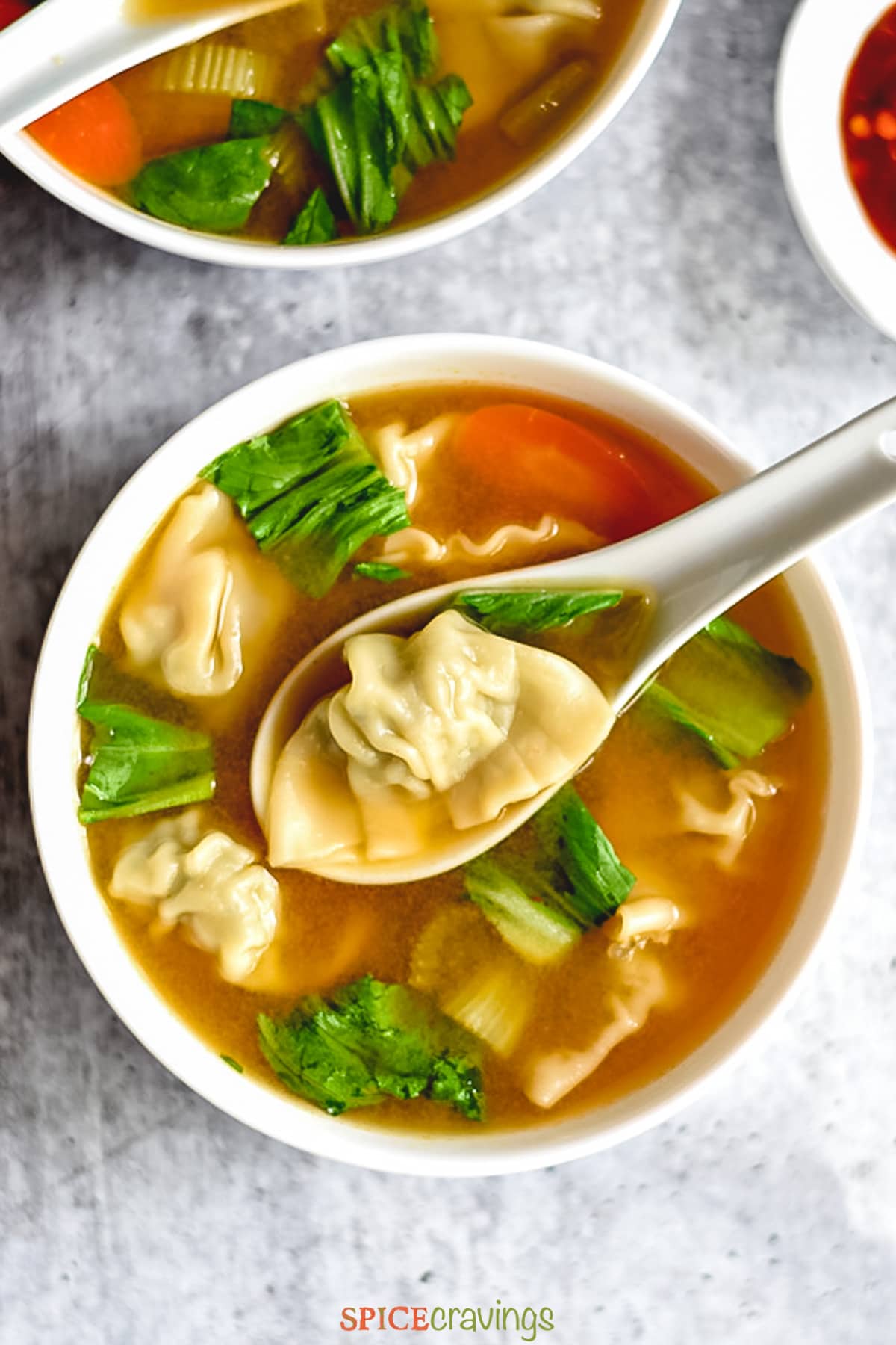 A bowl of clear soup with dumplings