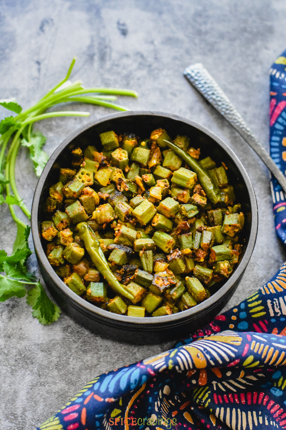 chopped okra, chile, onions and spices in black bowl