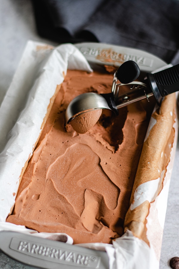 frozen chocolate dessert in loaf pan with ice cream scoop