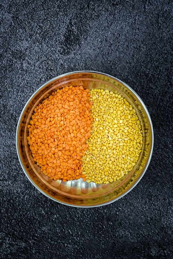 red and yellow lentils in stainless steel bowl
