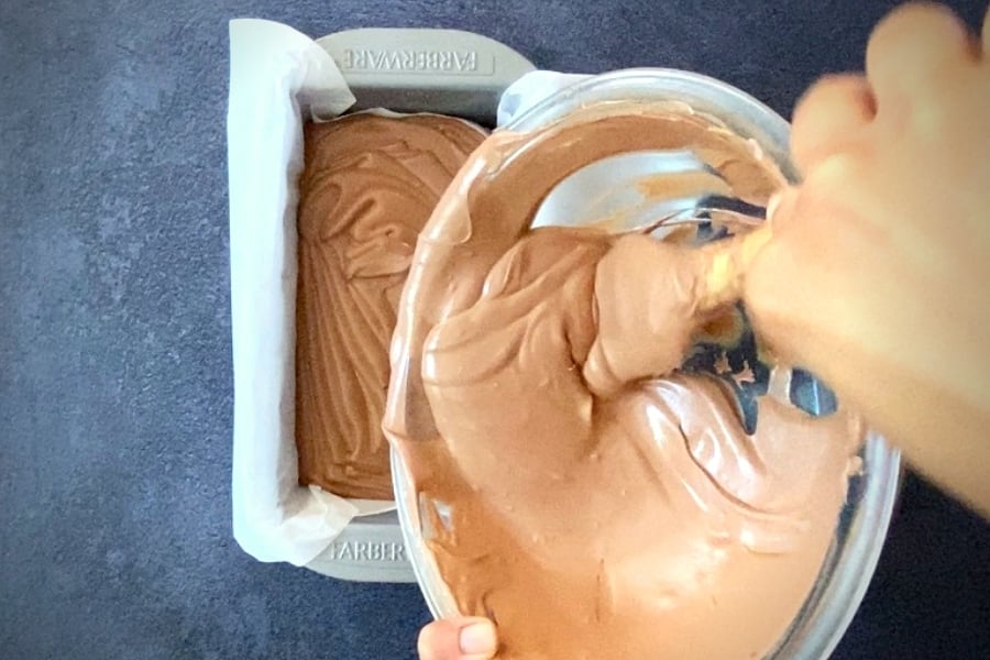 pouring chocolate ice cream batter into metal loaf pan