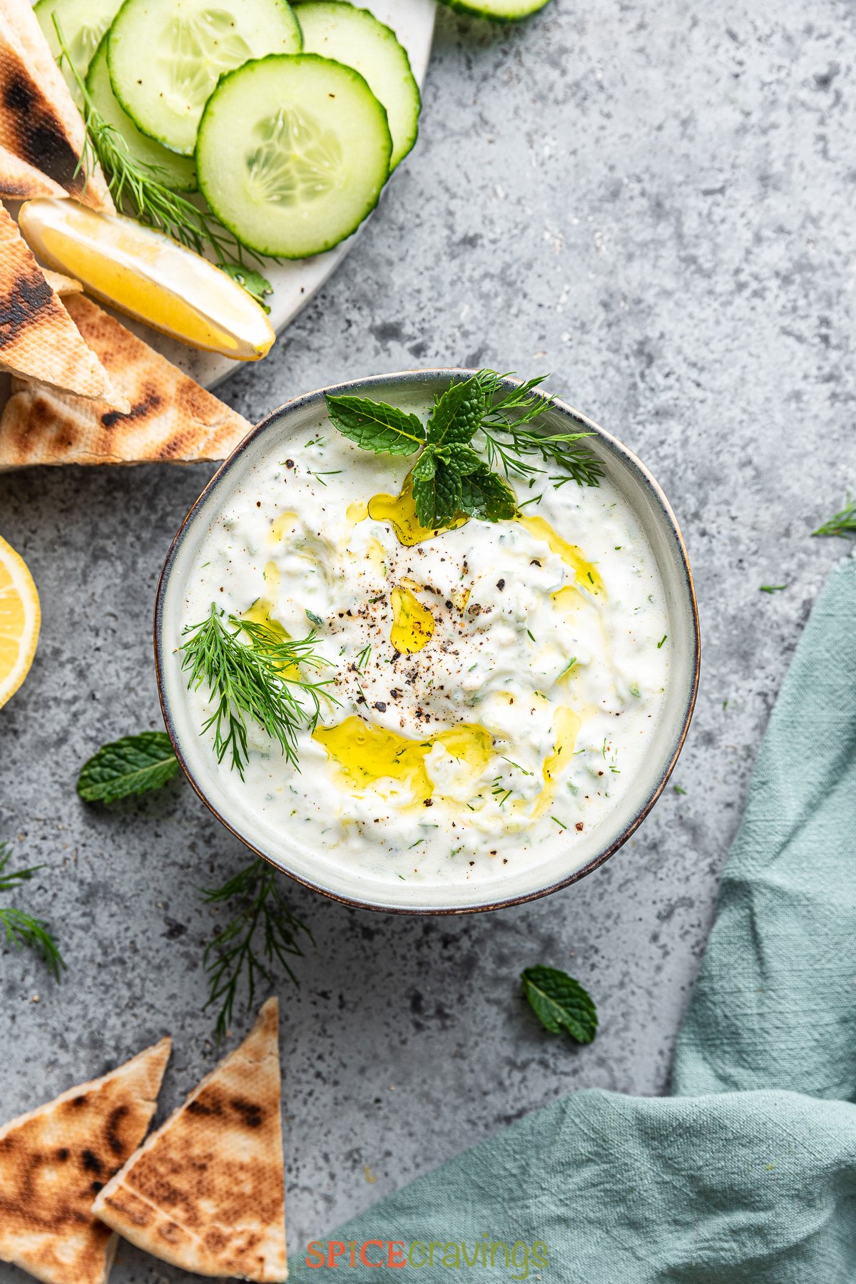 tzatziki sauce in bowl with mint, dill and olive oil on top