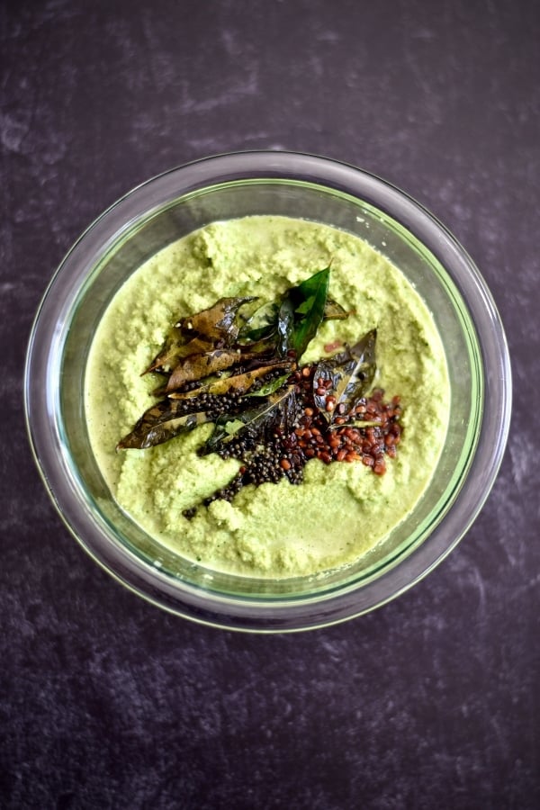 cilantro chutney topped with hot tadka in glass bowl