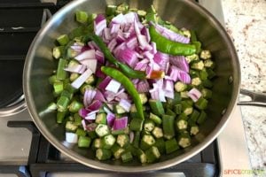 okra, onions and chile in nonstick skillet on stove