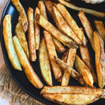 homemade french fries on black plate with fry sauce in white bowl