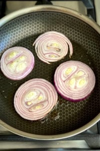 sliced red onion rings in nonstick skillet