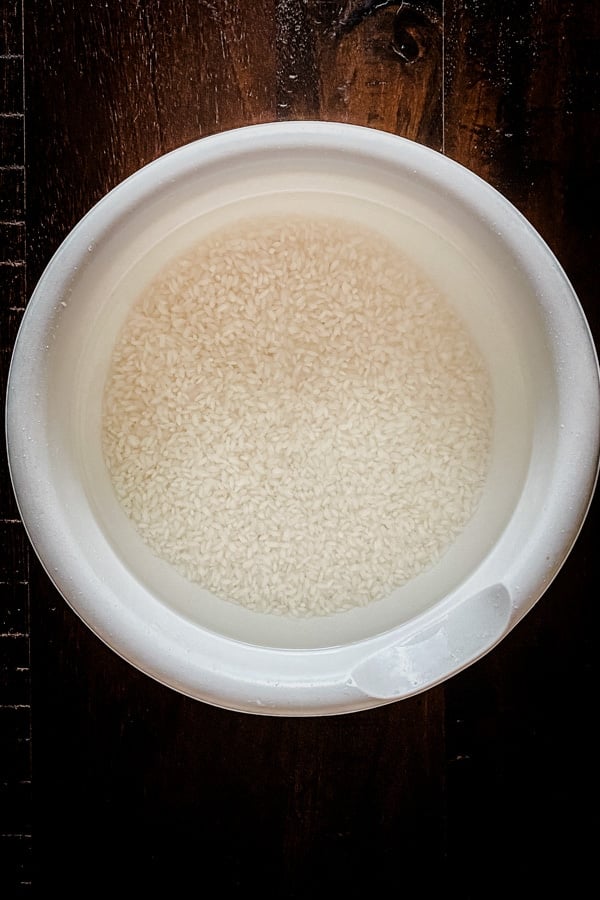 idli rice soaking in water in white bowl