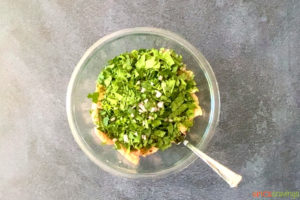 cilantro and spinach over ground chicken in glass bowl