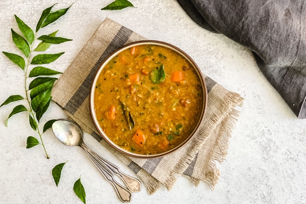 sambar recipe in bowl with two spoons
