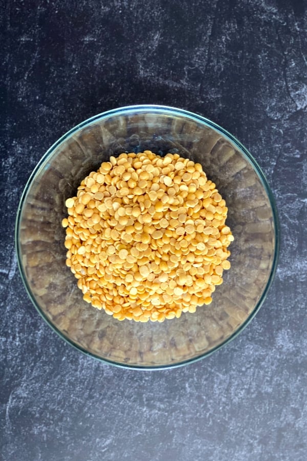 A bowl with yellow split pigeon peas, called toor dal in hindi