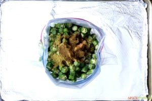 chopped okra and Indian spices in plastic storage bag on aluminum foil