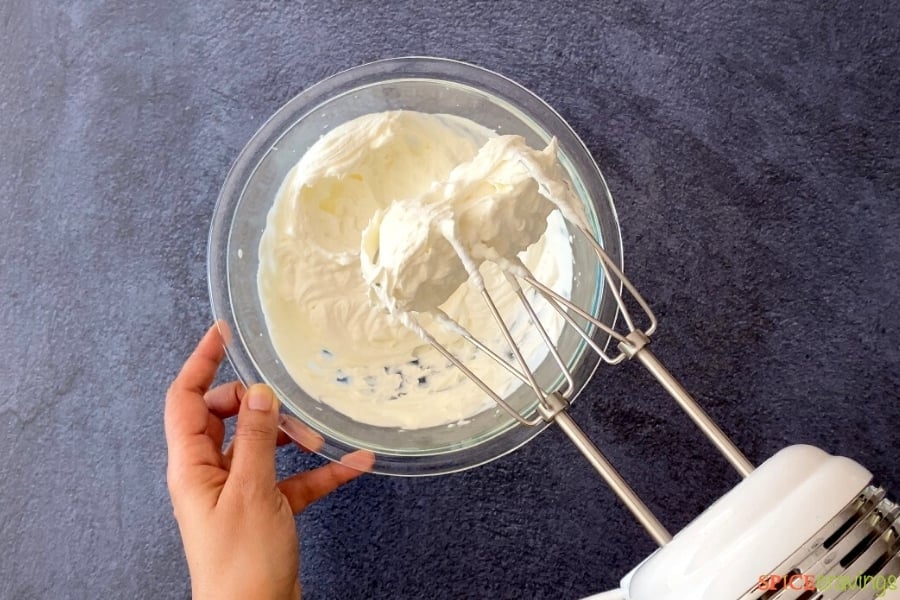 whipped cream in glass bowl with electric beaters