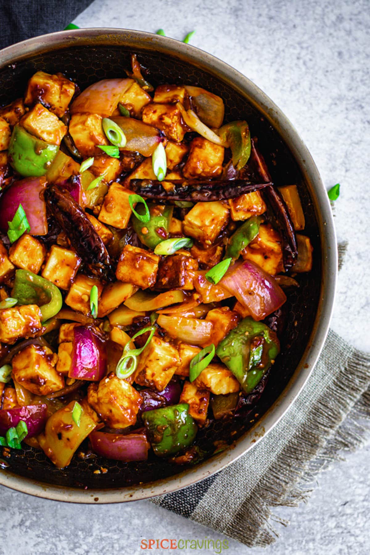 crispy chilli paneer recipe in stainless steel skillet with gray towel