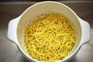 rinsed chinese noodles in white colander