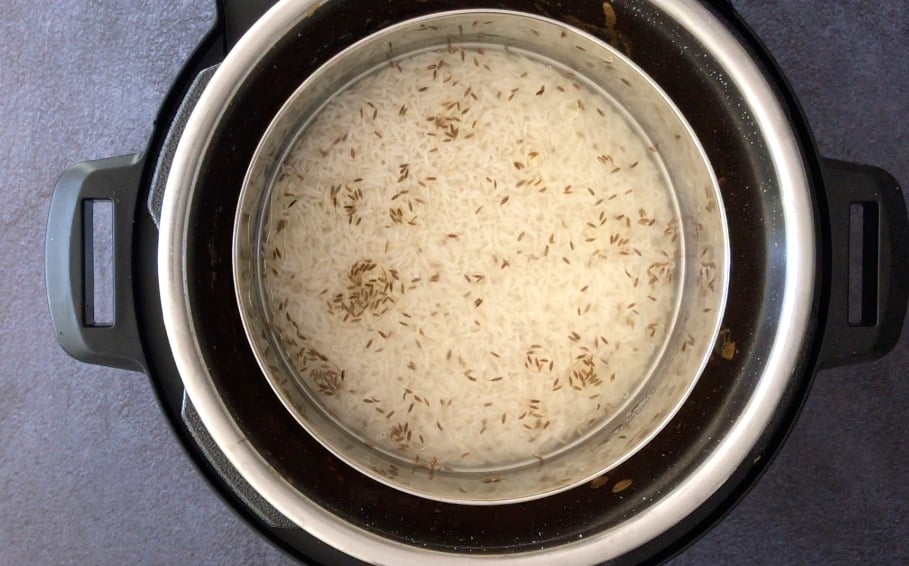 Adding a small bowl of rice, water and cumin seeds in the Instant Pot