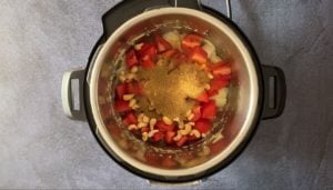 Adding tomato, spices and cashews to the pot