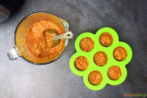 A measuring cup and silicone mold filled with Indian curry sauce