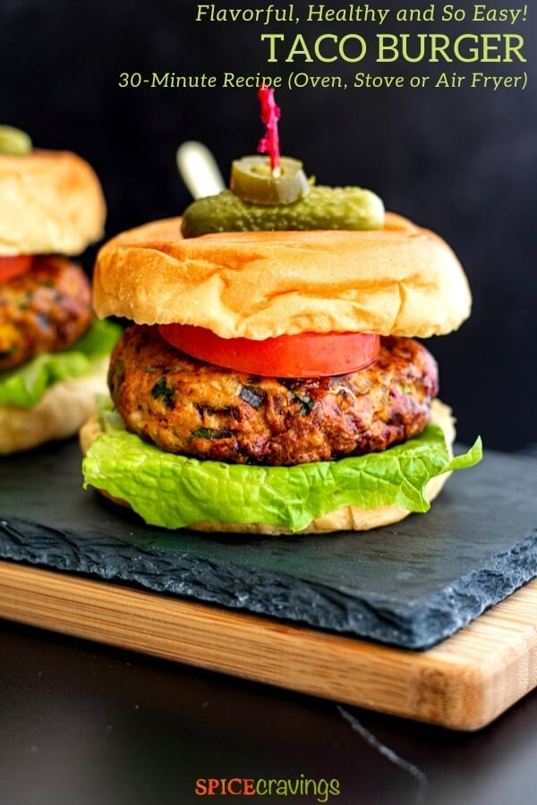 mexican chicken burger on buns with lettuce, tomato and skewered with pickle