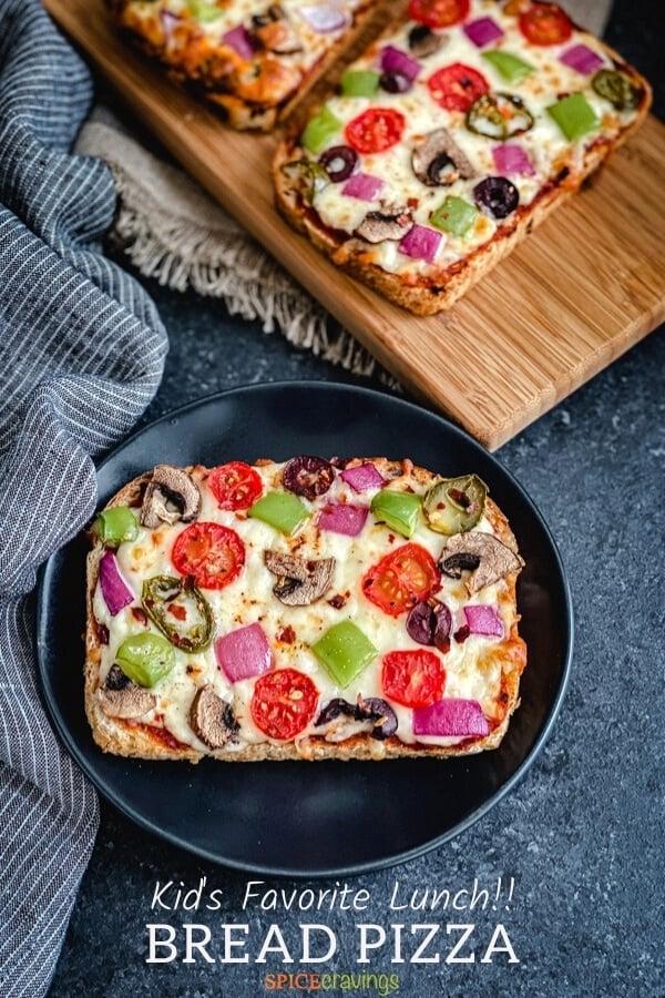 easy pizza bread recipe with fresh vegetables on black plate with blue napkin