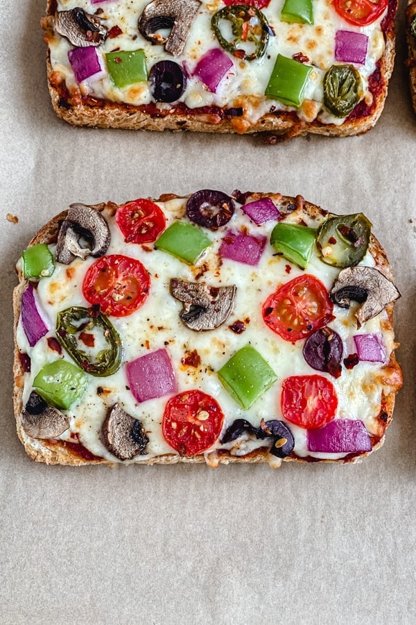 bread pizza recipe with fresh vegetables on parchment paper