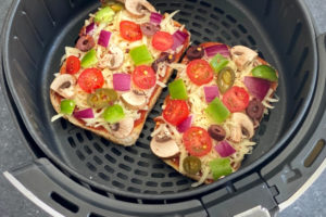 slices of bread, cheese and vegetable toppings in air fryer