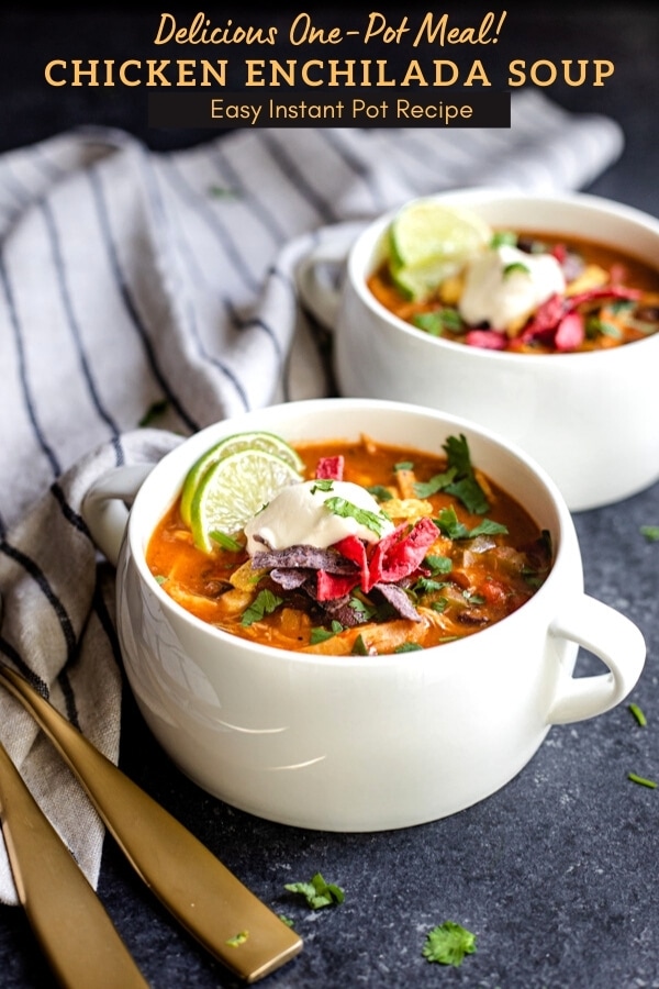cheesy enchilada soup in two white soup crocks topped with sour cream and tortilla strips