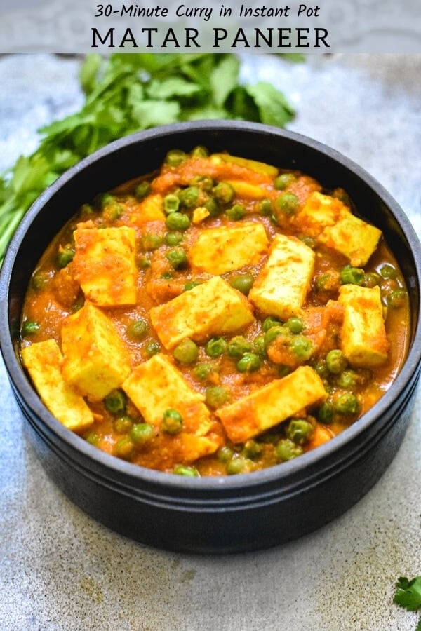 easy matar paneer recipe in black bowl with cilantro sprigs on silver platter