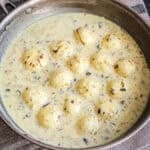 rasgulla balls in sweet cream with nuts, saffron and cardamom in bowl