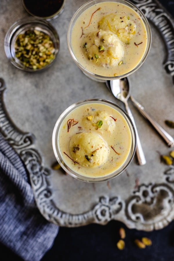 easy rasmalai recipe in glass coupes with pistachios and spoons on silver platter