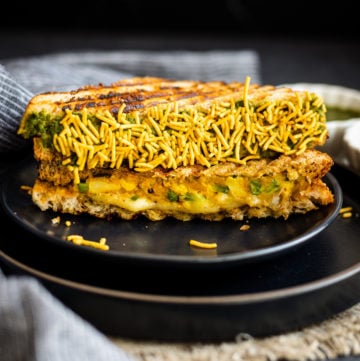 bombay cheese toastie coated in namkeen on black plate