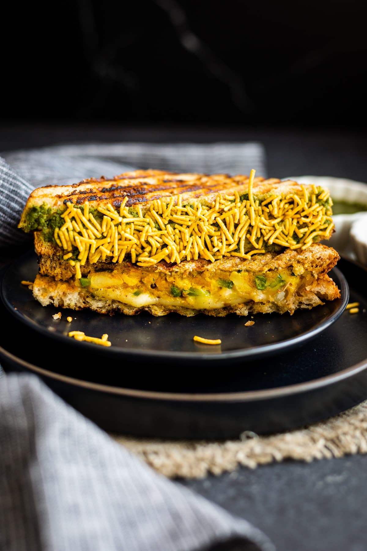 bombay cheese toastie coated in namkeen on black plate