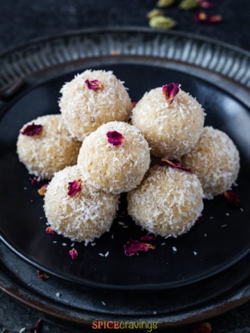 Coconut ladoo stacked on black plate