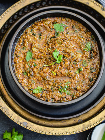 dhaba style keema in black bowl garnished with cilantro sprigs