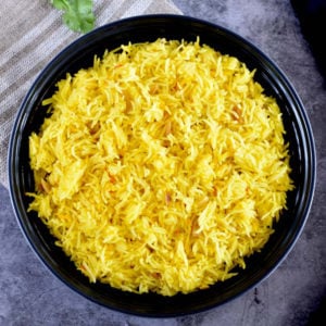 light golden and fragrant saffron rice in black bowl