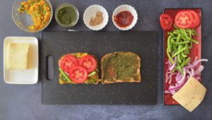 tomato slices on whole grain bread with small bowls of condiments on the side
