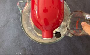 water pouring into bowl of red stand mixer
