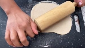 rolling out bhatura dough with rolling pin