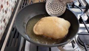 bhatura fry bread frying in hot oil on the stove