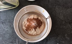 dry ingredients in fine mesh sieve over bowl