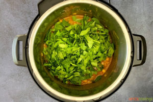 adding chopped spinach to chickpea curry in instant pot