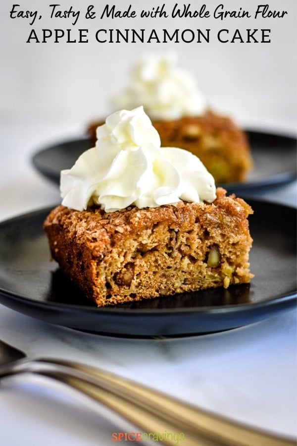 square of apple cinnamon cake on black plate topped with whipped cream